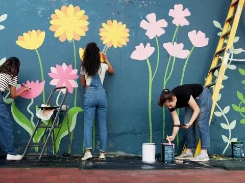 Members painting flowers on a community mural