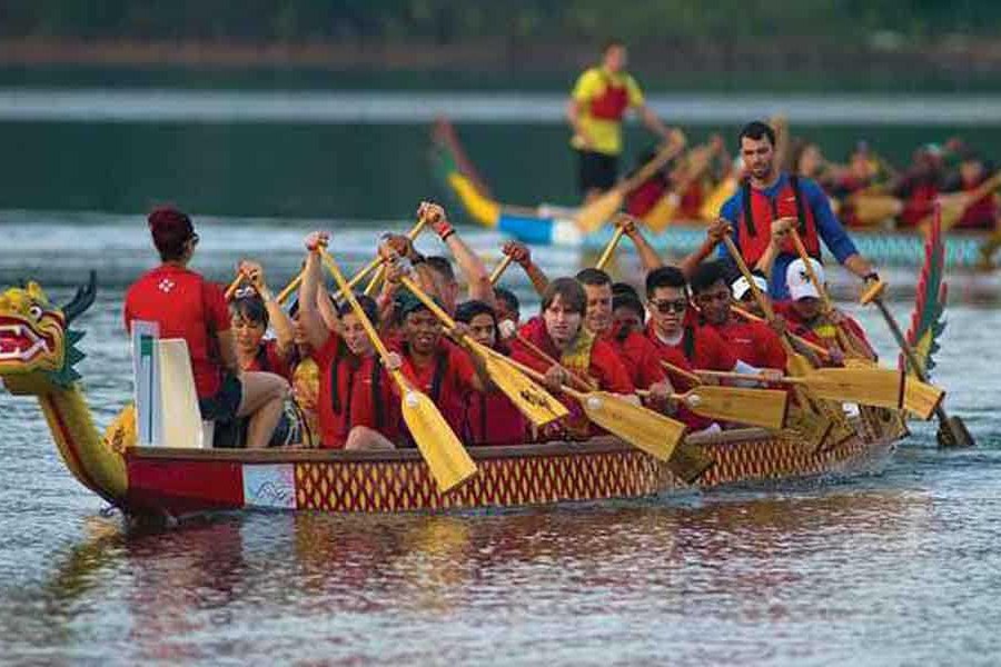 A dragon boat crew paddling in unison